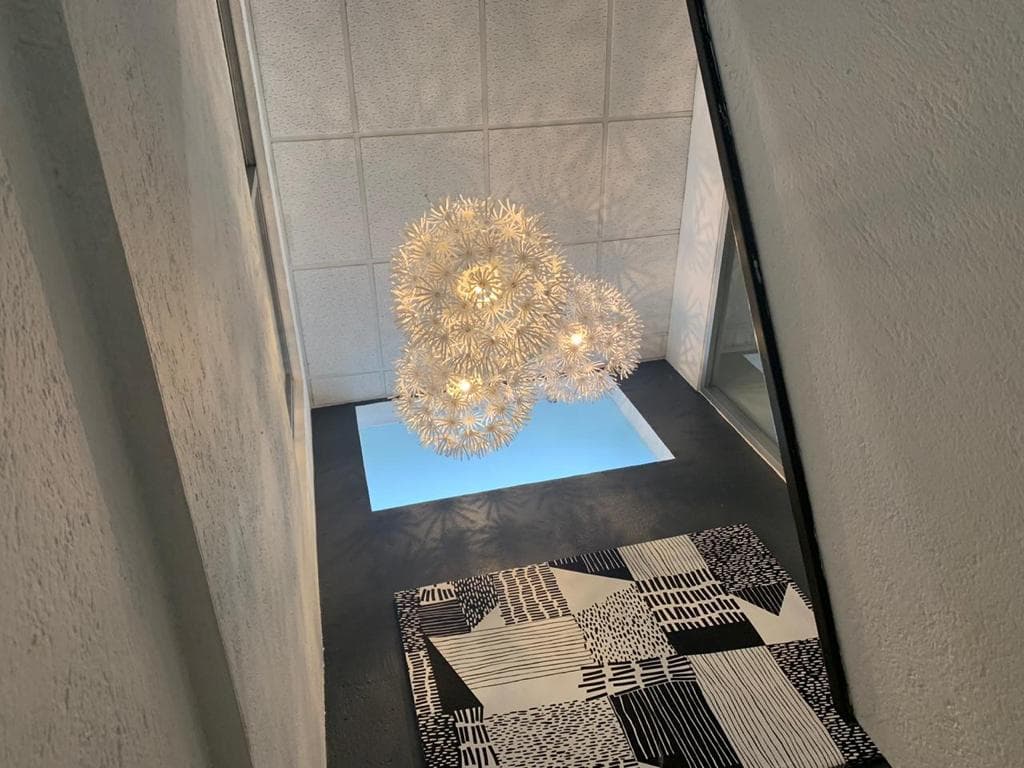 Escalera principal con lámpara decorativa tipo diente de león