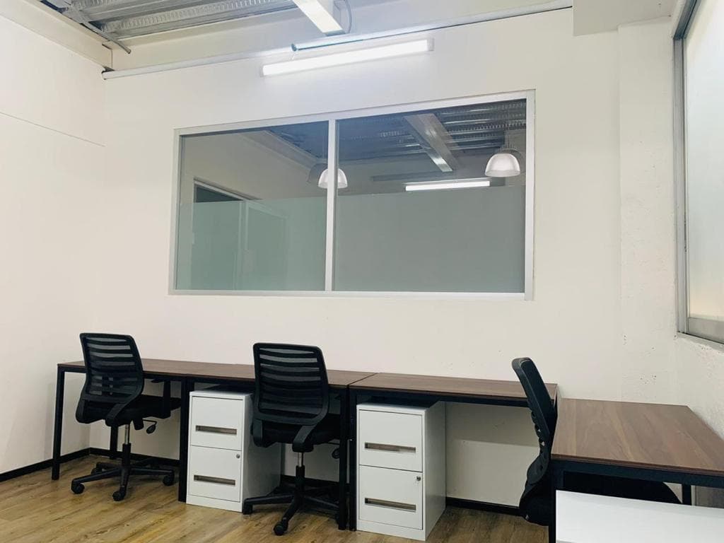 Oficina privada con tres escritorios, sillas ejecutivas y archiveros