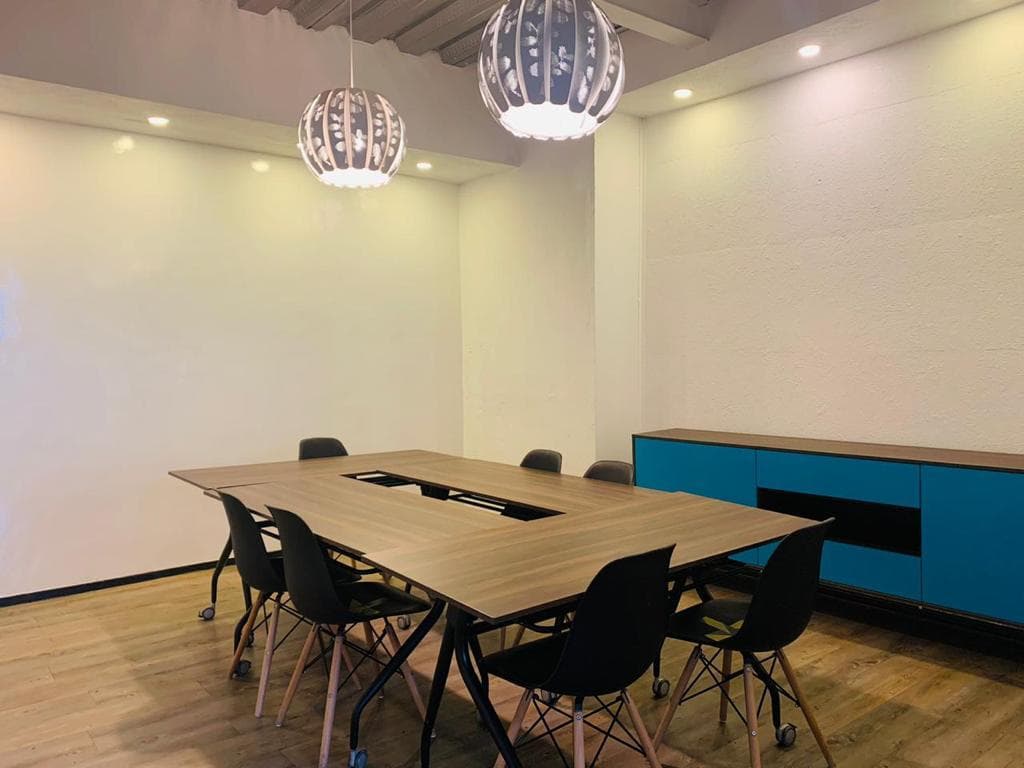 Sala de juntas con credenza azul y lámparas colgantes