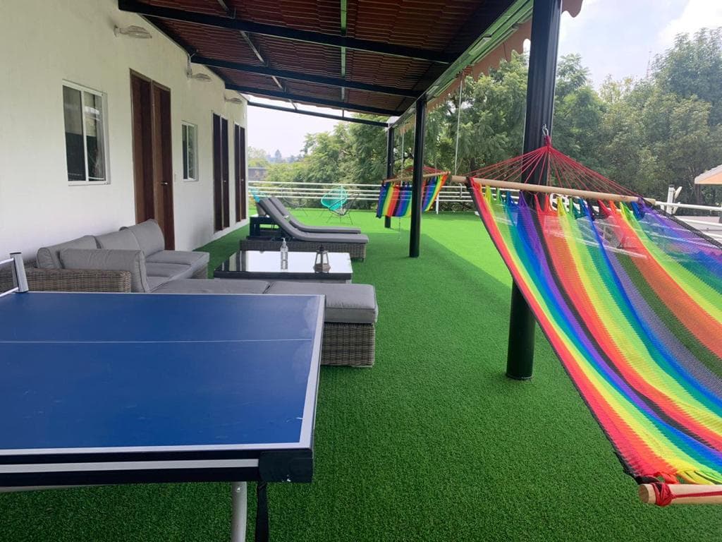 Terraza con pasto sintético, hamacas de colores, mesa de ping pong y sala exterior