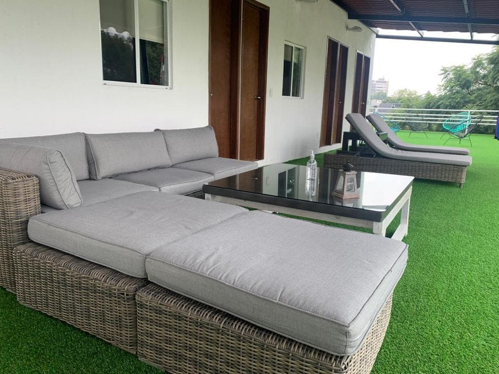 Sala exterior de ratán en la terraza con camastros